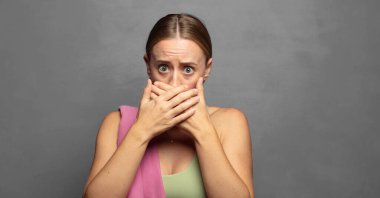 Şok olmuş, şaşırmış bir ifadeyle ağzı kapalı, sır saklayan ya da 