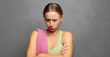 Hoşnutsuz ve hayal kırıklığına uğramış hissediyorum, ciddi görünüyor, kızgın ve çapraz kollara kızgın.