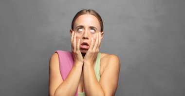 Şok olmuş ve korkmuş hissediyorum, yanaklarındaki ellerden sıkılmış gibiyim.