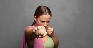 Kendinden emin, sinirli, güçlü ve agresif görünüyor. Yumrukları boks pozisyonunda dövüşmeye hazır.