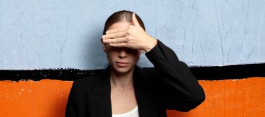 Bir eliyle gözlerini kapatıyor korkmuş ya da endişeli, merak ediyor ya da körü körüne bir sürpriz bekliyor.