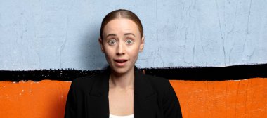 Şok olmuş ya da şaşırmış görünüyor, ağzı açık bakıyor ve 