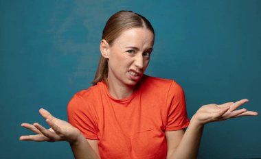 Şaşırmış, kafası karışmış ve stresli görünüyor, farklı seçenekler arasında merak ediyor, kararsız hissediyor.