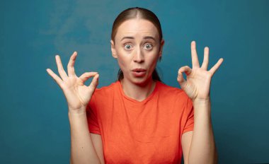 Şaşırmış, şaşırmış ve şaşırmış hissediyorsun. Onayladığını gösteriyorsun. İki elinle de onay imzası atıyorsun.