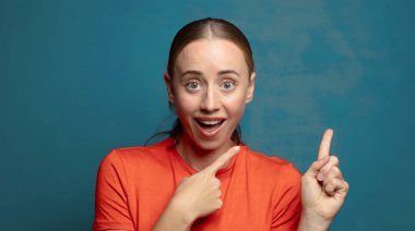 Neşeli ve şaşırmış hissediyorum, şok olmuş bir ifadeyle gülümsüyorum ve bir tarafı işaret ediyorum.