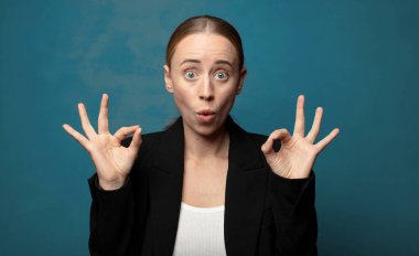 Şaşırmış, şaşırmış ve şaşırmış hissediyorsun. Onayladığını gösteriyorsun. İki elinle de onay imzası atıyorsun.