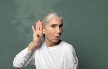  Ciddi ve meraklı görünmek, dinlemek, gizli bir konuşma ya da dedikodu duymaya çalışmak, kulak misafiri olmak.