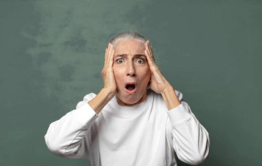  Heyecanlı ve şaşırmış görünüyor, ağzı açık, elleri başının üstünde, şanslı bir kazanan gibi hissediyor.