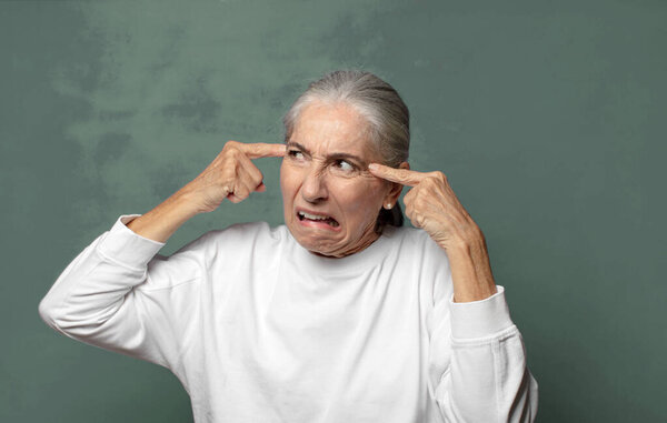  сердитой, напряженной и раздраженной, прикрывающей оба уха оглушительным шумом, звуком или громкой музыкой