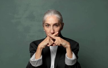  Ciddi ve hoşnutsuz görünüyor. İki parmağın önde olsun, reddedilmek üzere, sessizlik istiyorsun.