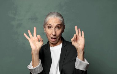  Şaşırmış, şaşırmış ve şaşırmış hissediyorsun. Onayladığını gösteriyorsun. İki elinle de onay imzası atıyorsun.