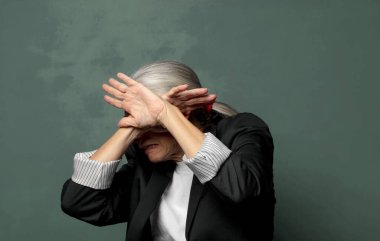  Yüzünü eliyle kapatıyor ve kamerayı durdurmak için diğer elini öne koyuyor, fotoğraf ya da resimleri reddediyor.