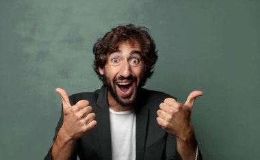  Neşeli bir şekilde gülümsüyor ve mutlu görünüyor, tasasız ve pozitif hissediyor.