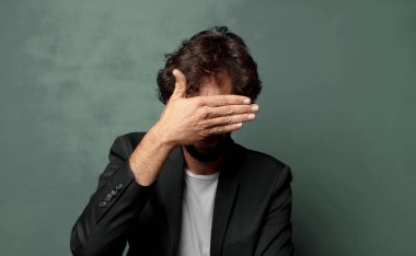  Bir eliyle gözlerini kapatıyor korkmuş ya da endişeli, merak ediyor ya da körü körüne bir sürpriz bekliyor.