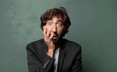  Şok ve inançsızlıkla ağzı açık, elleri yanakları ve kolları çaprazlanmış, sersemlemiş ve şaşkın.