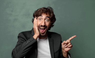  Gülüyor, mutlu, pozitif ve şaşırmış görünüyor. Yan fotokopi alanını işaret eden harika bir fikri fark ediyor.