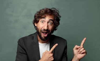  Neşeli ve şaşırmış hissediyorum, şok olmuş bir ifadeyle gülümsüyorum ve bir tarafı işaret ediyorum.