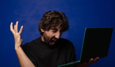 Dizüstü bilgisayarı olan genç sakallı deli adam.