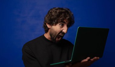 Dizüstü bilgisayarı olan genç sakallı deli adam.