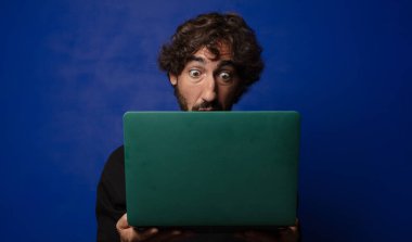 Dizüstü bilgisayarı olan genç sakallı deli adam.