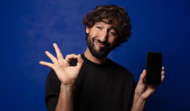 Akıllı telefonlu genç sakallı deli adam.