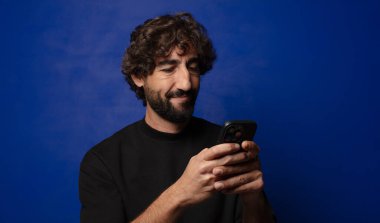 Akıllı telefonlu genç sakallı deli adam.