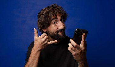 Akıllı telefonlu genç sakallı deli adam.