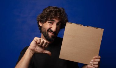 Boş defter kapağı olan genç sakallı deli adam.