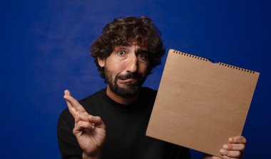 Boş defter kapağı olan genç sakallı deli adam.