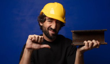 Genç, sakallı, kasklı çılgın işçi.