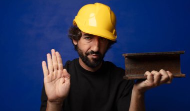 Genç, sakallı, kasklı çılgın işçi.