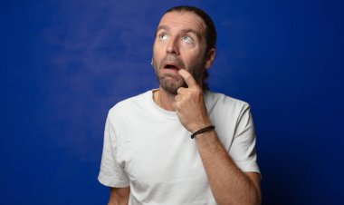 Şaşırmış, gergin, endişeli ya da korkmuş bir bakışla, kopya boşluğuna doğru bakıyor.