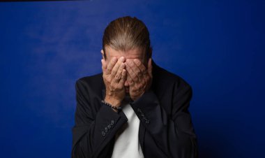 Üzgün, hayal kırıklığına uğramış, gergin ve depresif, iki eliyle yüzünü kaplayan, ağlayan