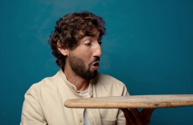 Boş bir masası olan genç, sakallı bir adam.