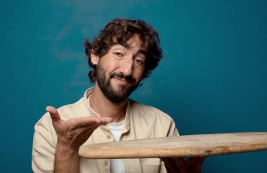 Boş bir masası olan genç, sakallı bir adam.