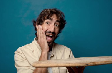 Boş bir masası olan genç, sakallı bir adam.