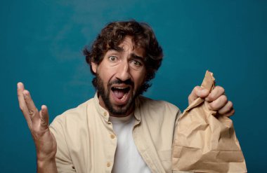 Kese kağıdıyla sakallı genç bir adam.