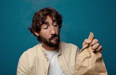 Kese kağıdıyla sakallı genç bir adam.