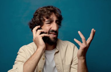 Akıllı telefonu olan genç, sakallı bir adam.