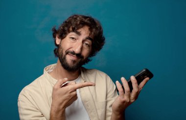 Akıllı telefonu olan genç, sakallı bir adam.