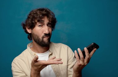 Akıllı telefonu olan genç, sakallı bir adam.