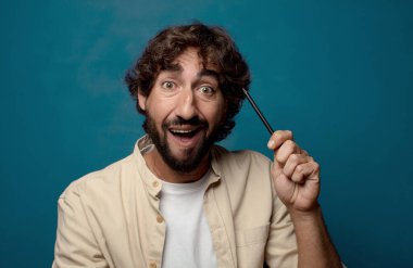 Genç, sakallı, kalemli bir adam.