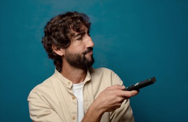 Uzaktan kumandalı sakallı genç bir adam.