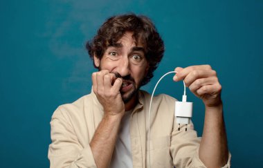 Genç, sakallı, akıllı telefon şarj aleti.