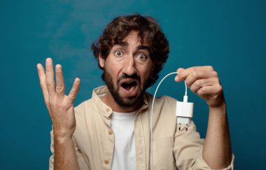 Genç, sakallı, akıllı telefon şarj aleti.