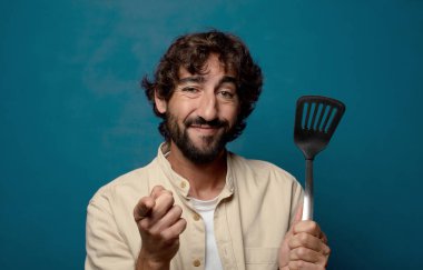 Genç yetişkin sakallı adam yemek pişirme konsepti