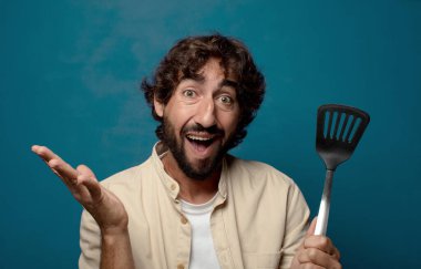 Genç yetişkin sakallı adam yemek pişirme konsepti