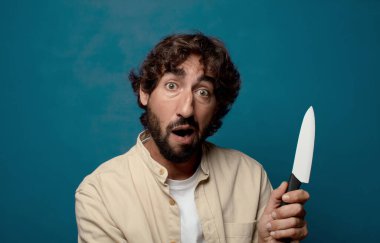 Genç, sakallı, bıçaklı bir adam.