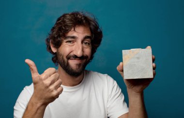 Taştan bir tuğlası olan sakallı genç bir adam.