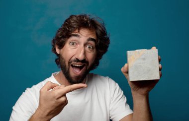 Taştan bir tuğlası olan sakallı genç bir adam.